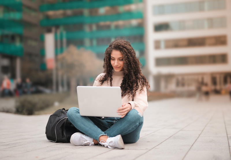 Mujer joven usando una computadora portátil con eSIM al aire libre
